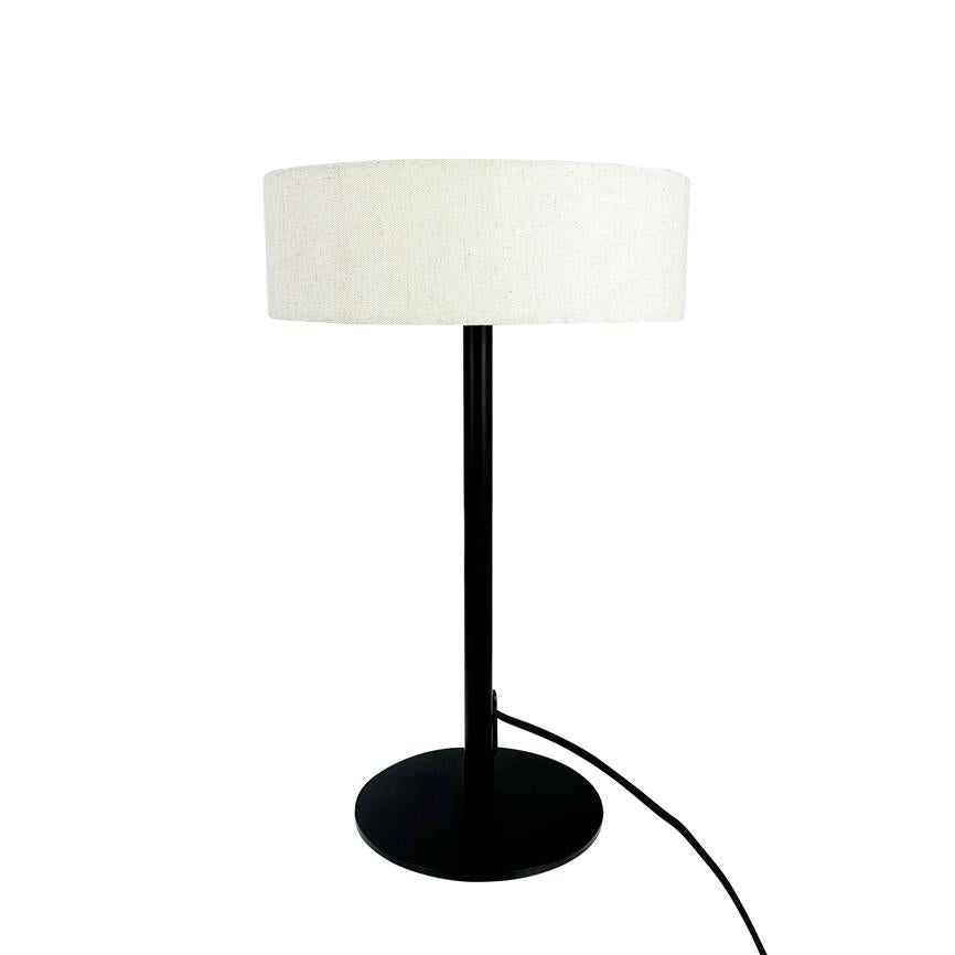 Bordlampe med sort metalstang og rund fod, bærer en hvid cylindrisk stofskærm; en sort ledning løber fra foden, placeret mod en neutral hvid baggrund.