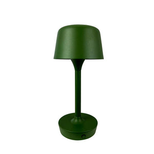 En mat grøn bordlampe står oprejst; slank central stang forbinder rund base og kuppelformet skærm, placeret alene mod en hvid baggrund.