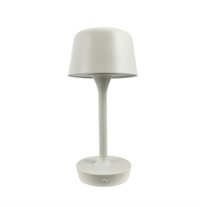 En hvid bordlampe står oprejst med en afrundet skærm og slankt skaft; rund base med lille cirkulær trykknap, placeret mod en ensartet hvid baggrund.