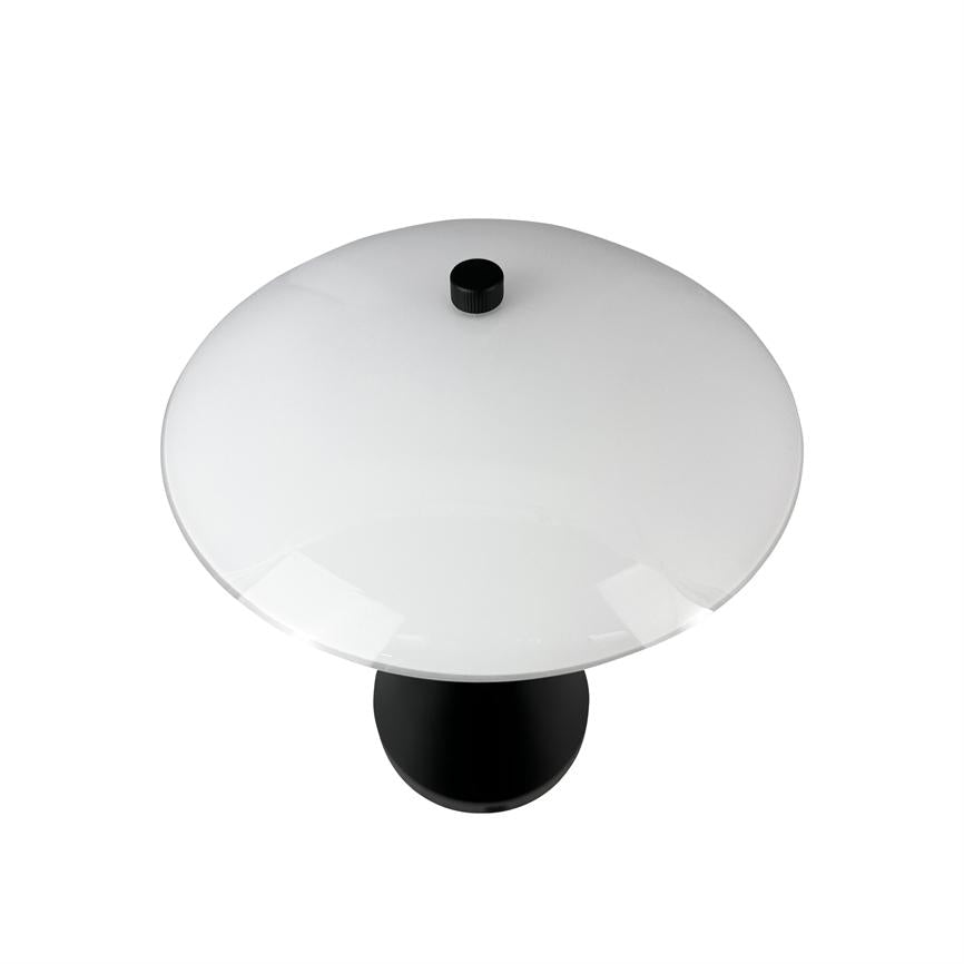Bordlampe står alene på hvid baggrund; den har en stor rund hvid kuppel med en sort knop øverst og en sort cylindrisk fod, set oppefra.