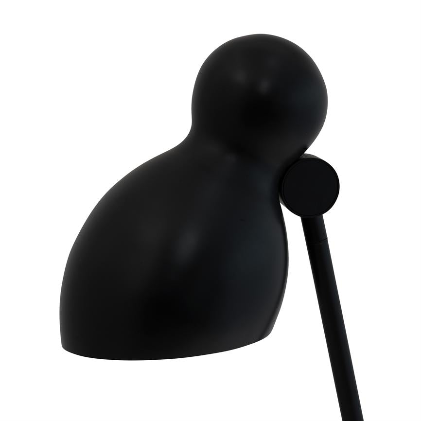 Sort, rundet lampehoved vipper let fremad på en tynd stang, rettet nedad over en ren, hvid baggrund; minimalistisk, mat overflade.