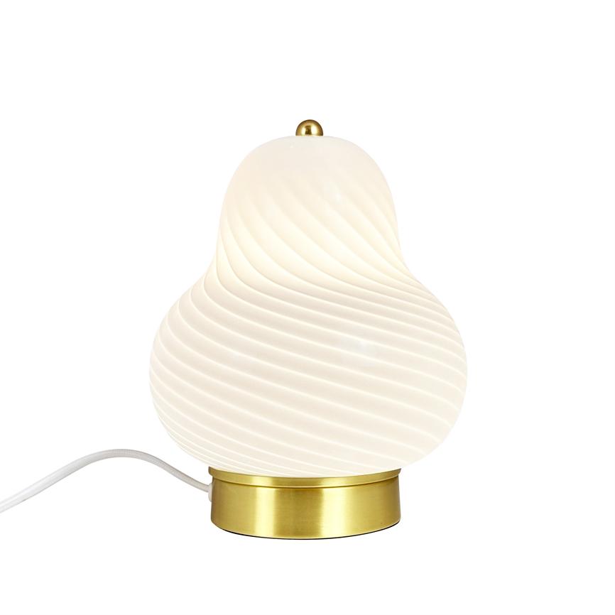 Bordlampe i hvidt, snoet glas udstråler blødt, varmt lys; placeret på rund messingfod med hvid ledning, fotograferet isoleret mod en hvid baggrund.
