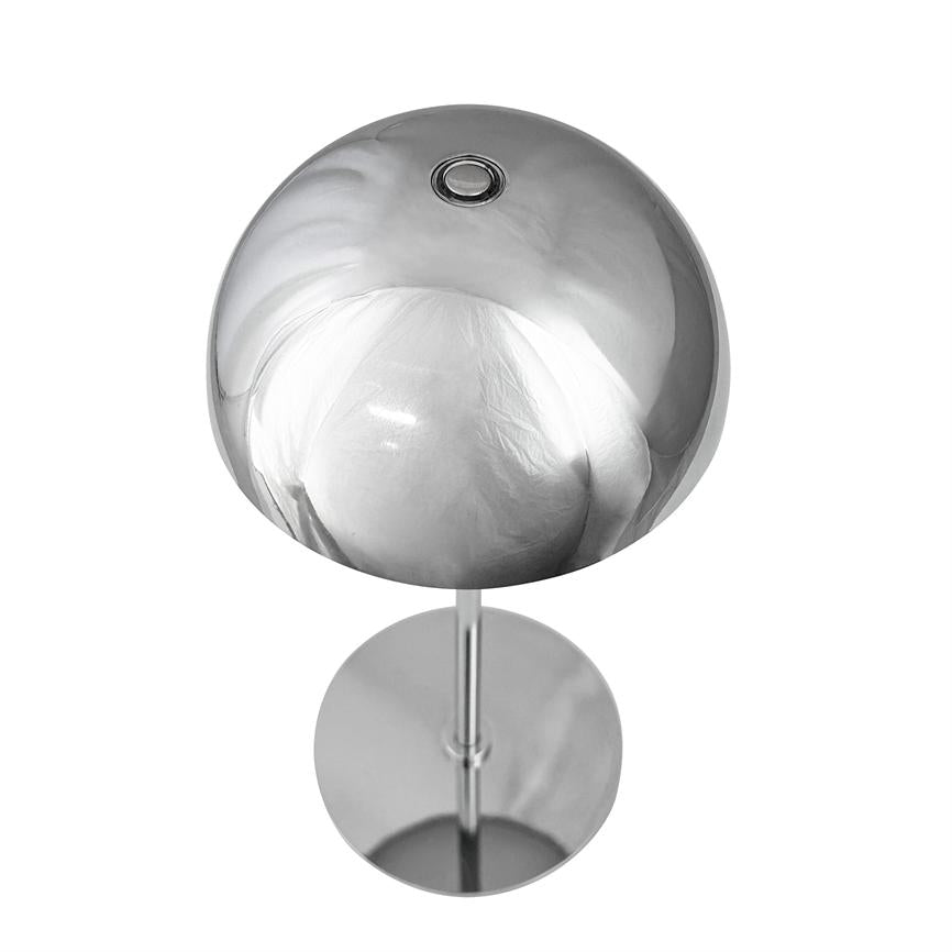 Krom bordlampe med rund, spejlblank kuppel og lille cirkulær åbning på toppen; kuppelen står på en tynd stang og rund fod, reflekterer en neutral, hvid baggrund.
