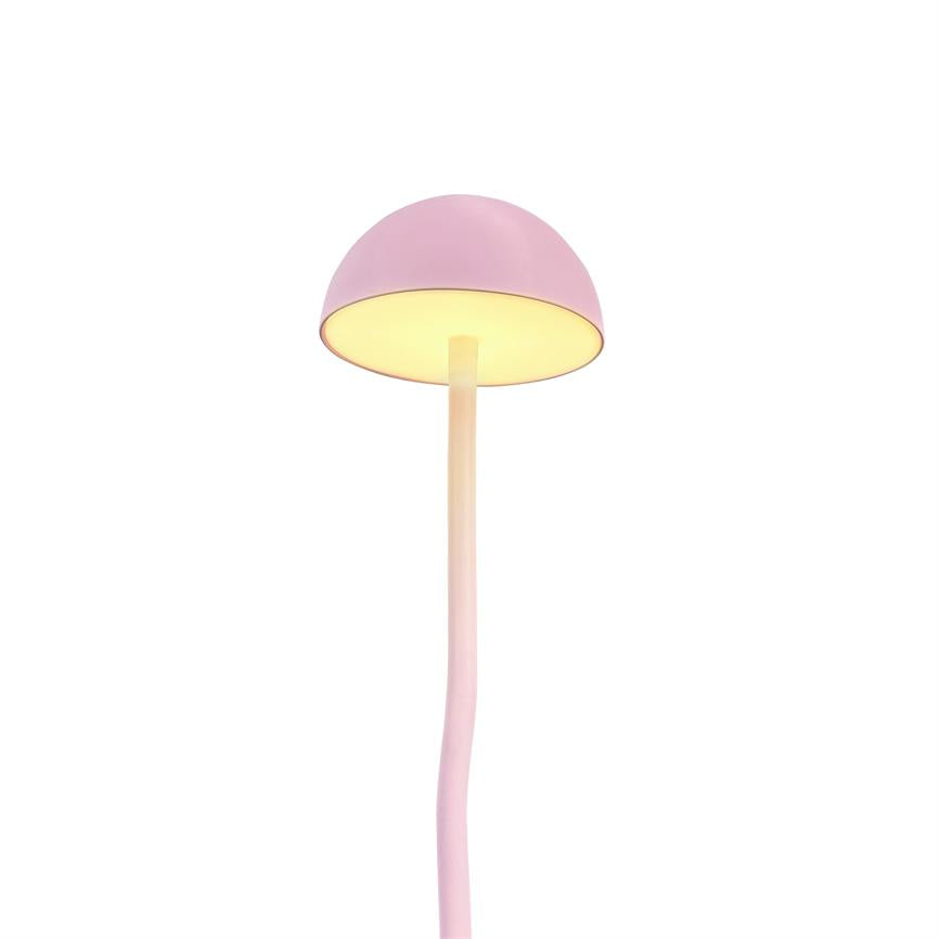 En lyserød, svampeformet bordlampe bøjer med en slank, let krum stilk; lampeskærmen lyser varmt nedad og står alene mod en klar, hvid, minimalistisk baggrund.