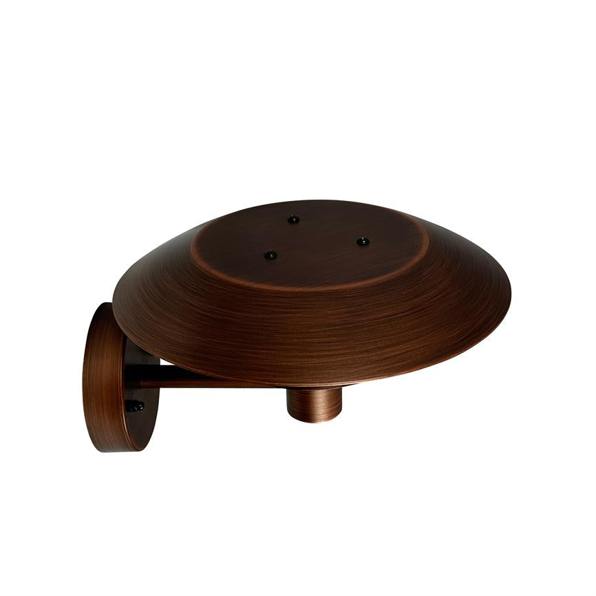 En rund, kobberbrun væglampe med bred, skålformet skærm, monteret på en kort arm; skærmen peger nedad og lampen har en børstet metalfinish mod en hvid baggrund.