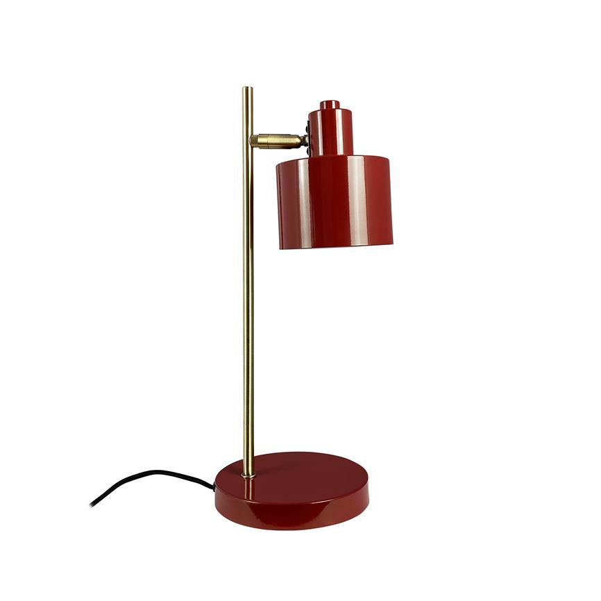 Bordlampe i rød metal med gylden stang, skærm rettet nedad, stående på rund rød fod; sort strømledning ligger ved siden af på hvid baggrund.
