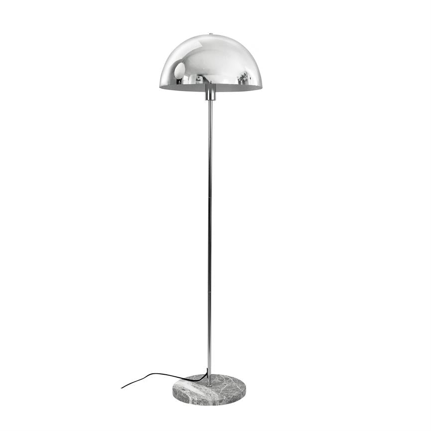 En krom gulvlampe med halvkugleformet skærm står på en slank stang og rund marmorfod; sort ledning ligger løst på hvid baggrund i et tomt, lyst miljø.
