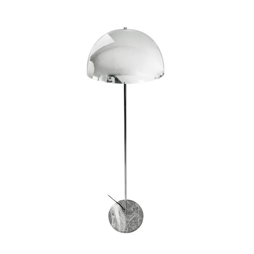 En høj, moderne gulvlampe står oprejst; krom halvkugleskærm, slank metalstang og rund marmorfod på en hvid, minimalistisk baggrund.