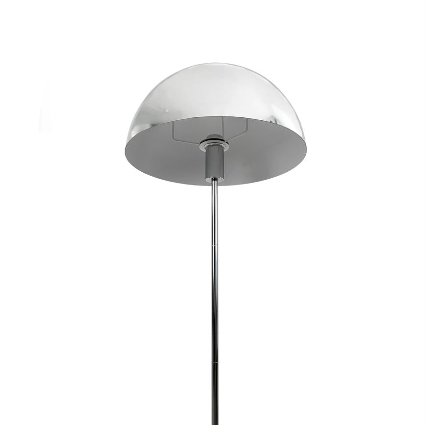 Krom halvkugleformet gulvlampe monteret på en slank, lodret stang; skærmen vender nedad og antyder rettet belysning. Isoleret mod en ensartet hvid baggrund.