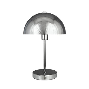 Bordlampe med blank krom halvkugleskærm står på en slank stang og rund base; enkel, moderne form mod en neutral hvid baggrund.
