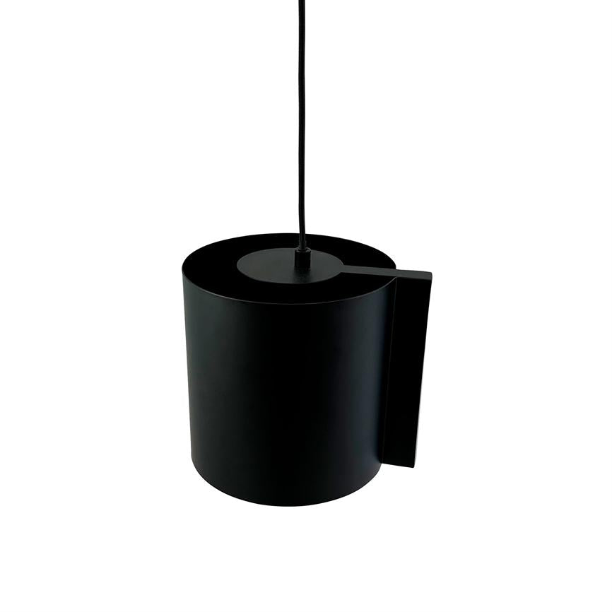 En sort, cylindrisk pendel hænger i en tynd sort ledning; lampe med flad top og aflang sideplade mod en ensartet hvid baggrund.