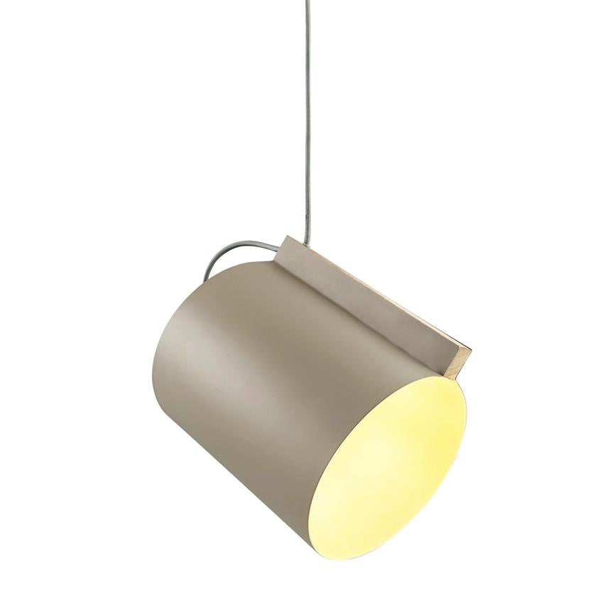 Cylinderlampe hænger i et kabel, udsender varmt gult lys fra åben bund; mat beige yderside med lille metalskinne mod en ren, hvid baggrund.