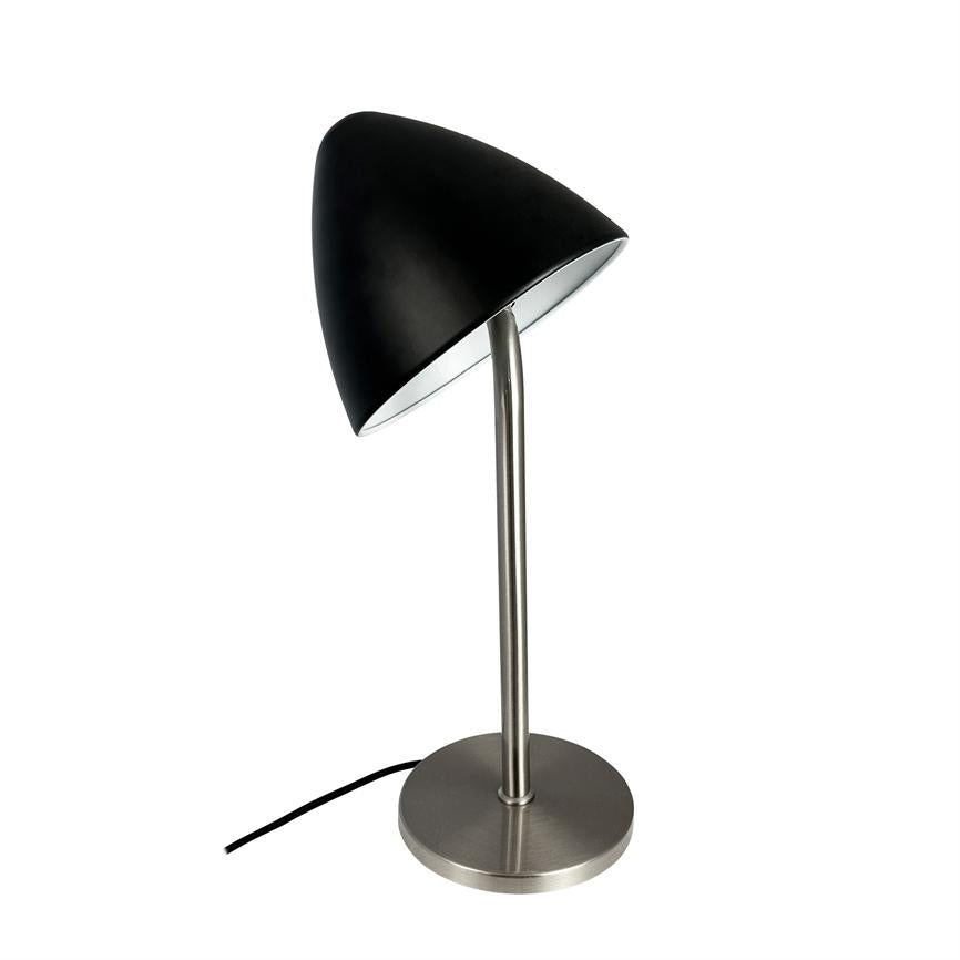 Sort bordlampe står på en slank metalstang og rund fod, skærmen er skråt vinklet nedad; enkel, moderne design med mat sort kuppel og synlig sort ledning mod hvid baggrund.