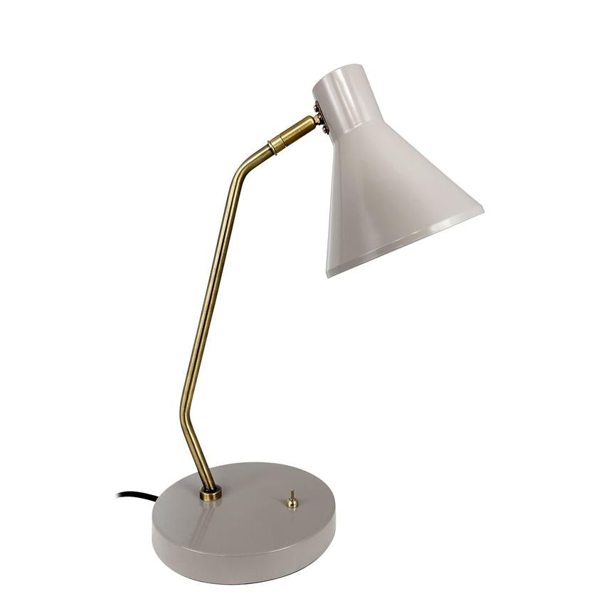 En lysgrå skrivebordslampe peger sin koniske skærm nedad; en buet messingsøjle forbinder skærm og rund grå base på en ens hvid baggrund.