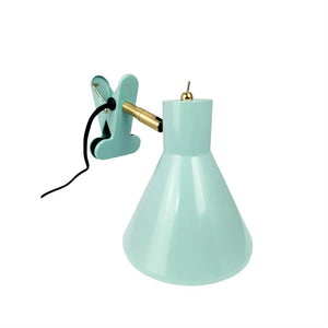 Mintgrøn klemme-lampe med konisk skærm, vinklet messingarm og sort ledning, beregnet til at klemme fast på en kant, fotograferet foran hvid baggrund.