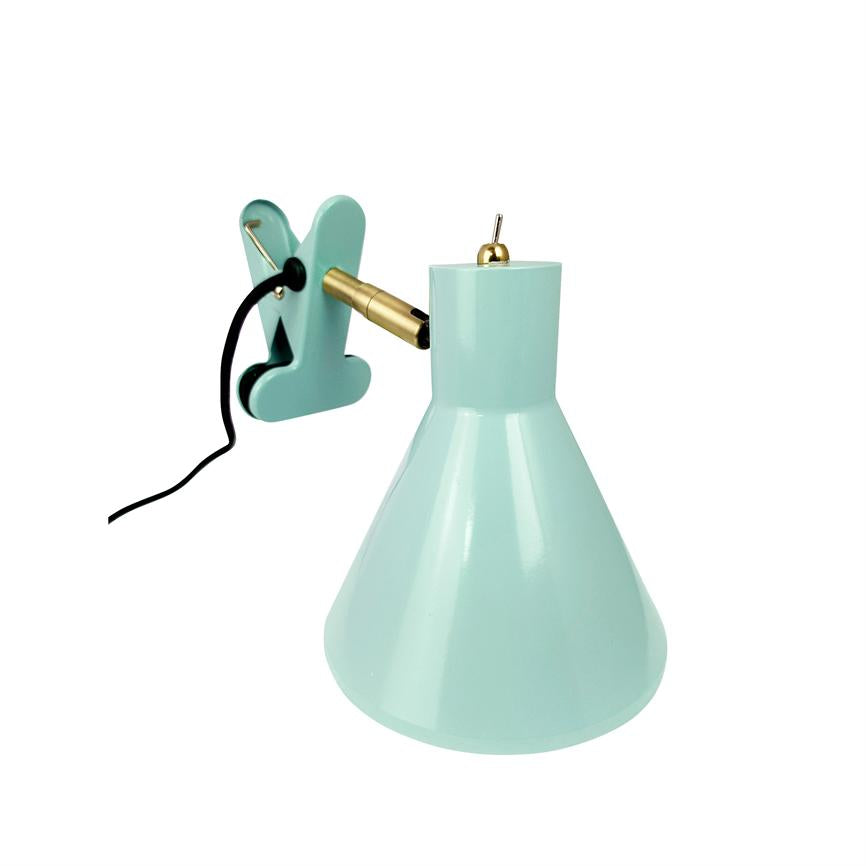 Mintgrøn klemme-lampe med konisk skærm, vinklet messingarm og sort ledning, beregnet til at klemme fast på en kant, fotograferet foran hvid baggrund.