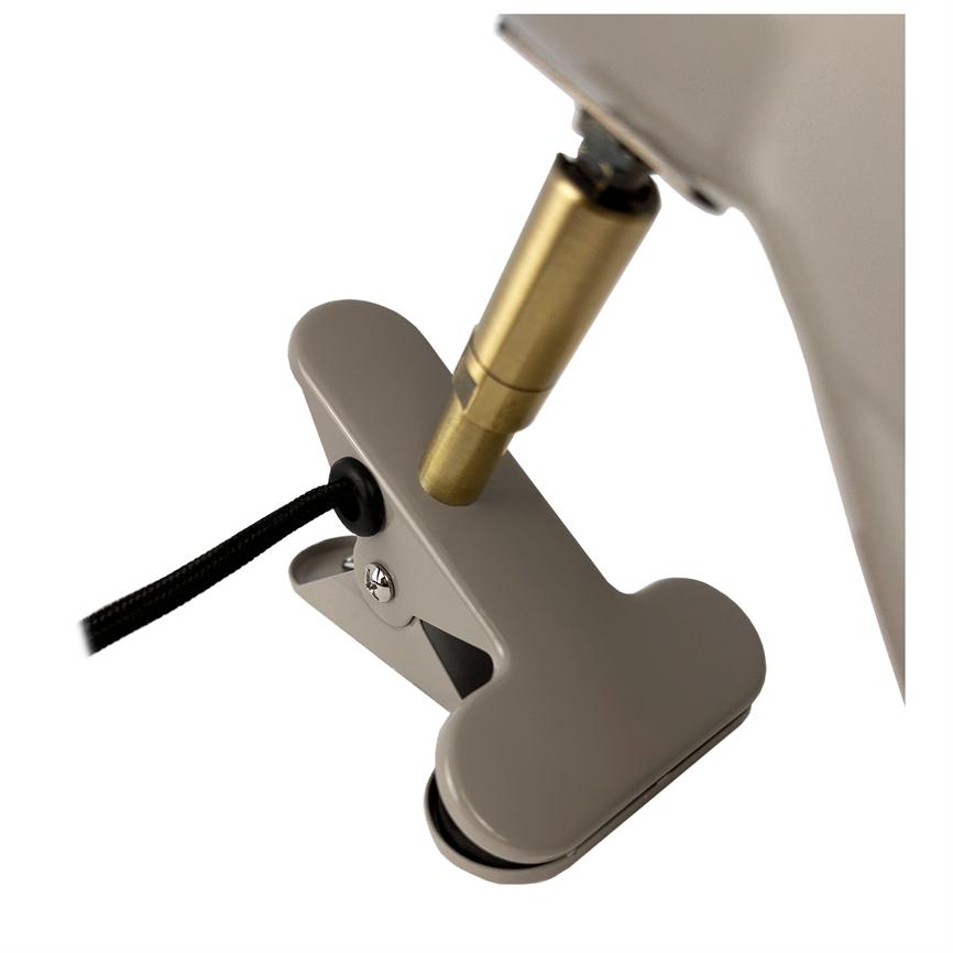 Beige metalklemme, åben, holder et sort tekstilbeklædt kabel ved en messingfarvet lampebeslag på en lampearm, fotograferet mod en hvid baggrund.