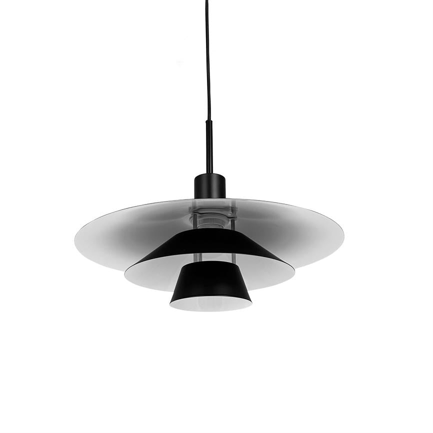En moderne hængelampe hænger i en sort ledning, med lagdelte sorte og gennemsigtige skærme, placeret mod en ren hvid baggrund i et minimalistisk studie.
