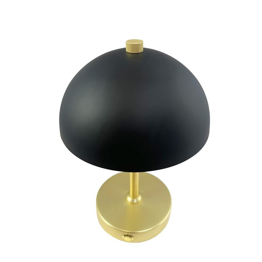 Matt sort, halvkugleformet bordlampe med gylden fod og lille drejeknap; står centralt på hvid baggrund.