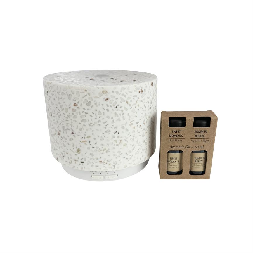 En hvid terrazzo aromadiffuser står ved siden af en kartonæske med to små aromatiske olieflasker på en hvid baggrund.
 
 Tekst: 
 SWEET MOMENTS
 Pure Vanilla
 SUMMER BREEZE
 My Lemon Verbena
 Aromatic Oil - 10 ml.