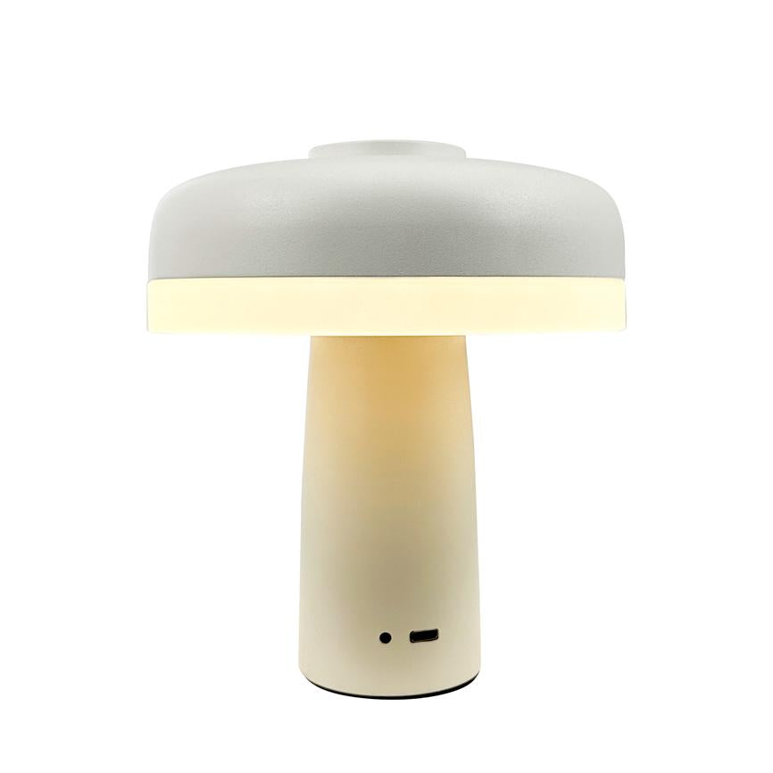 Bordlampe lyser varmt og jævnt med et blødt lysbånd ved skærmkanten; enkel svampeformet skærm og cylindrisk fod, cremehvid overflade, USB-port i bunden, alene på hvid baggrund.