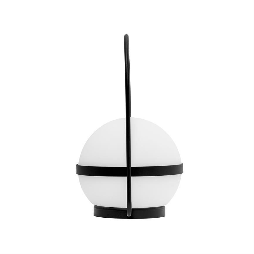En sfærisk bordlampe står på en rund sort fod; et hvidt opalglas omgives af en sort metalring og et lodret sort håndtag, mod en ensartet hvid baggrund.