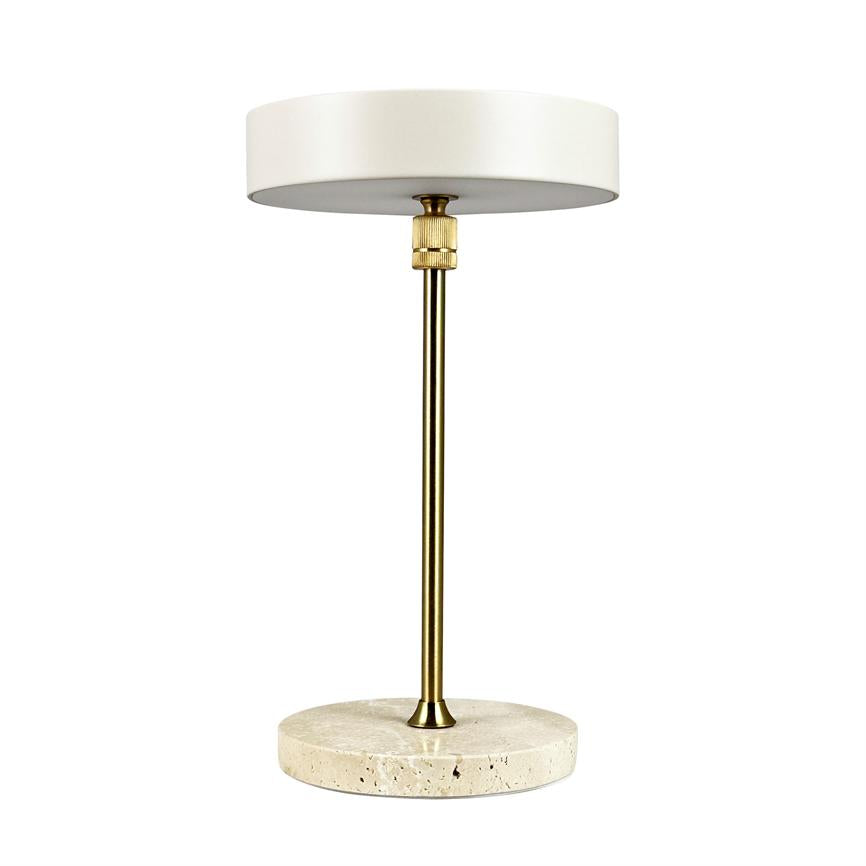Bordlampe står mod hvid baggrund; rund, mat hvid skærm, slank messingstang og rund travertinfod i lys sten.