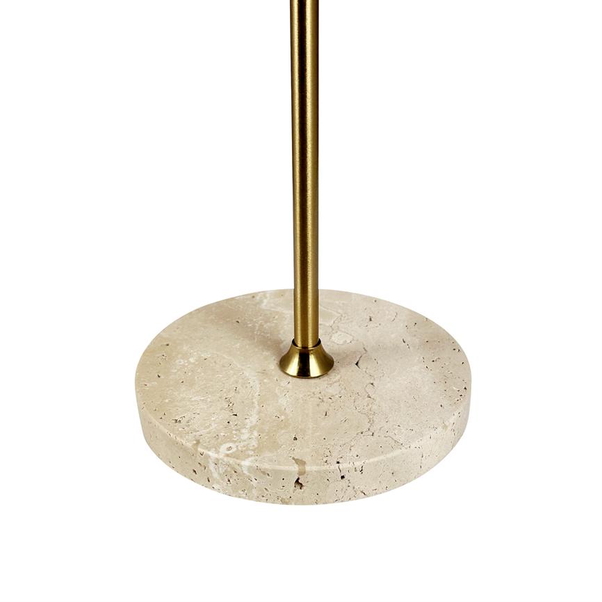En rund beige stenbase støtter en slank guldfarvet metalstang; elementet står centreret og isoleret mod en ensartet hvid baggrund, med synlige stenporer og poleret overflade.