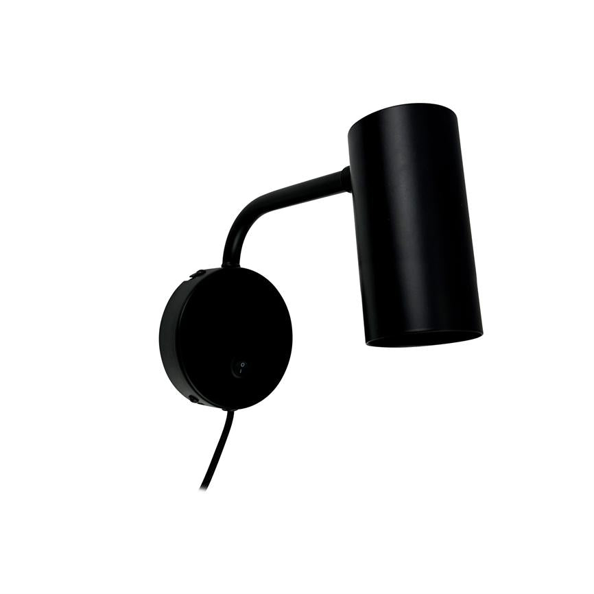 Sort væglampe monteret på en rundt vægbeslag, arm buet opad og cylindrisk lampskærm vinklet nedad, med synlig ledning mod en hvid, ensartet baggrund.