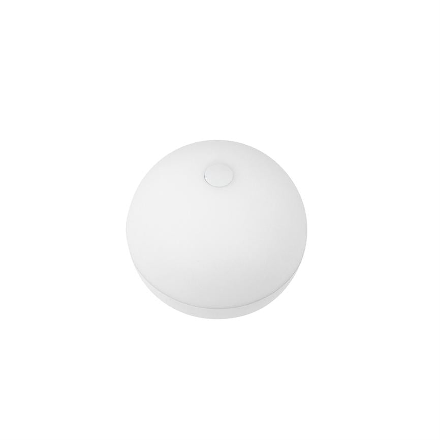 Rund, hvid enhed med en lille cirkulær knap på toppen ligger stille på en ensartet hvid baggrund; set ovenfra som en skiveformet gadget eller sensor placeret centralt.