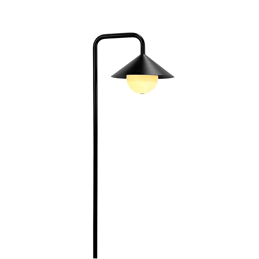 Sort stående lampe med buet stang og konisk skærm; rund, varmglødende pære lyser dæmpet under skærmen mod en ensartet hvid baggrund.