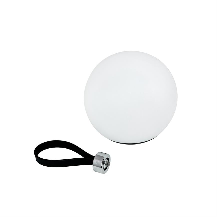 Globeformet hvid lampe står på fladt underlag; ved siden af ligger en sort rem med metalbeslag på en hvid, studieagtig baggrund.