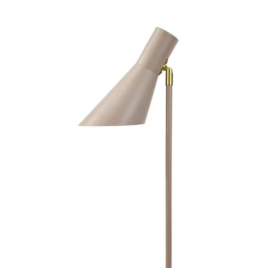 En beige metal gulvlampe, skærmen vinklet nedad; skærmen er aflang og monteret på en tynd stang via et lille gyldent hængsel, mod en ensartet hvid baggrund.