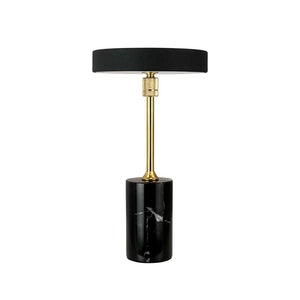 Sort bordlampe står oprejst; en rund sort skærm hviler på en smal forgyldt stang, som sidder på en cylindrisk sort marmorfod på hvid baggrund.