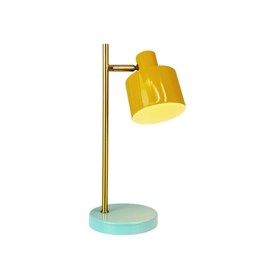 Gul bordlampe vinklet nedad, fastgjort til en slank guldfarvet stang på rund mintgrøn base; lyser varmt fra skærmen mod en enkel hvid baggrund.