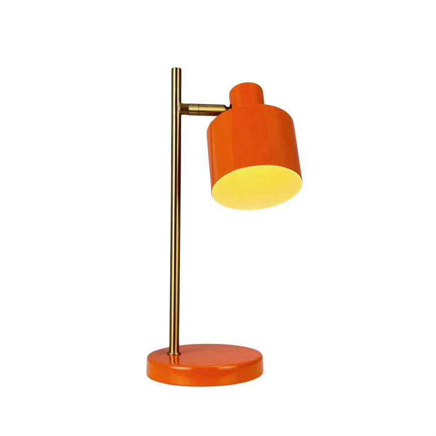En orange bordlampe lyser nedad; skærmen er cylinderformet og vippet på en lodret messingstang, der står på en rund orange base mod en ensartet hvid baggrund.