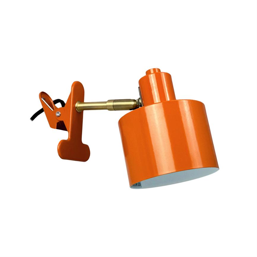 Orange klemme-lampe med åben klemme og vinklet lampeskærm; et kort guldfarvet led forbinder skærmen og klemmen mod en ensartet hvid baggrund.
