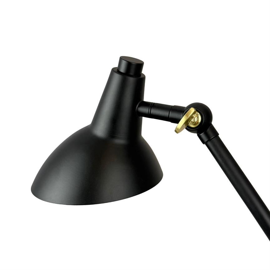 Sort metal skrivebordslampe retter lyset nedad; justerbart led og drejeled fastgjort med en gylden skrue; isoleret på hvid baggrund uden omgivelser.