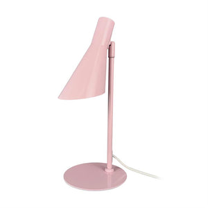 Lyserød skrivebordslampe, skærm vippet skråt nedad, monteret på slank stang og rund fod; hvid ledning ligger bøjet ved basen mod en ensartet hvid baggrund.
