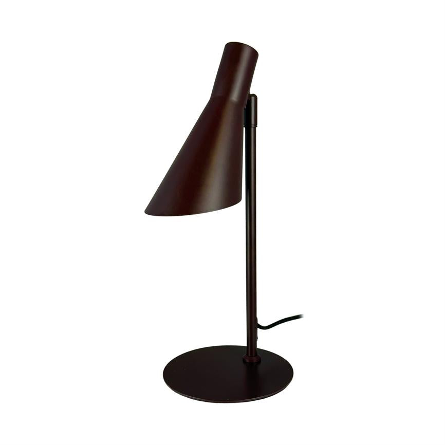 Bordlampe med aflang, skråtstillet metalskærm; skærmen peger nedad fra en lodret stang, som står på en rund fod. Lampen er mørkebrun og præsenteret mod hvid baggrund.