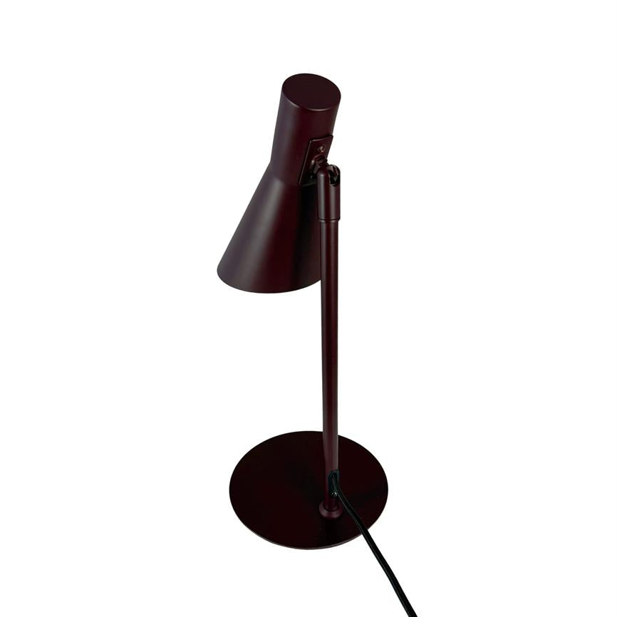 Bordlampe med slank metalstand, vinklet konisk skærm peger nedad; står på rund fod med synlig sort ledning, placeret mod ensartet hvid baggrund.