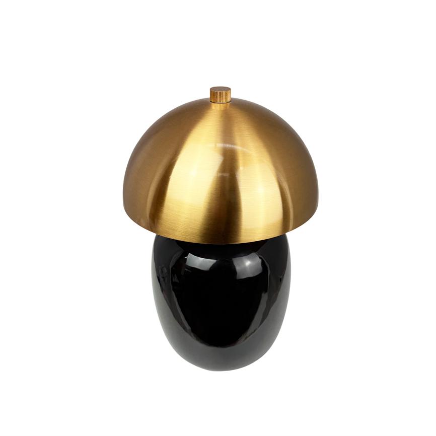 Bordlampe med rund, messingfarvet kuppel; står på blank, sort oval fod; omgivet af en ensartet hvid baggrund.
