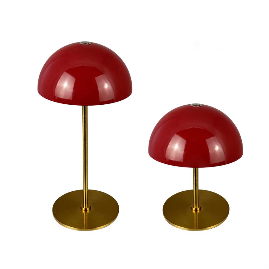 To runde, røde bordlamper med kuppelskærme står på slanke gyldne metalstængler; den ene er højere, begge på flade runde guldbaser mod hvid baggrund.