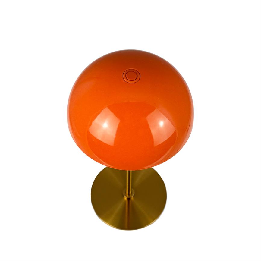 Kuglelampe med blank orange glaskuppel, monteret på slank messingstang og rund messingfod; kuppelen reflekterer lys og lampen står mod en ren hvid baggrund.