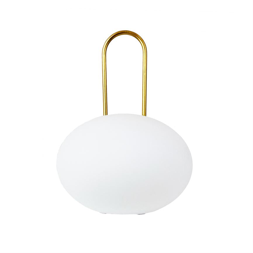 Rund hvid lampe står på overfladen og bærer et gyldent, U-formet håndtag; objektet er centreret mod en ren, hvid baggrund.