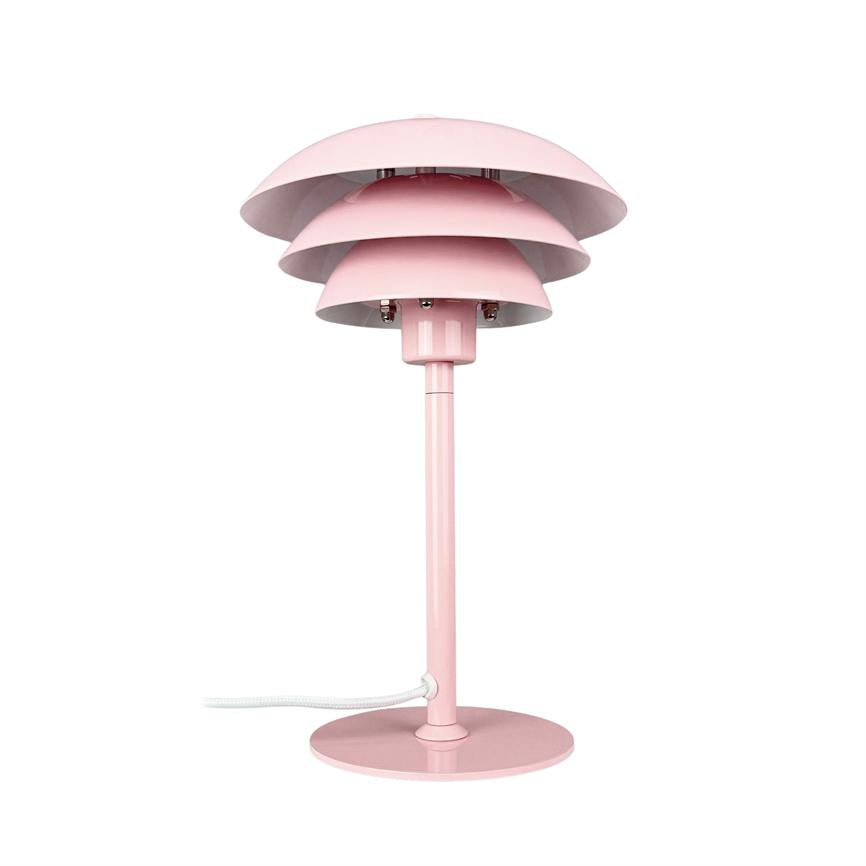 En lyserød bordlampe med tre lagdelte skærme, står på en rund fod og slank skaft; en hvid stofledning ligger ved foden på en hvid baggrund.